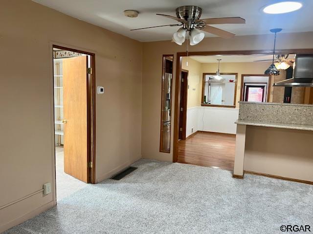 carpeted spare room with ceiling fan