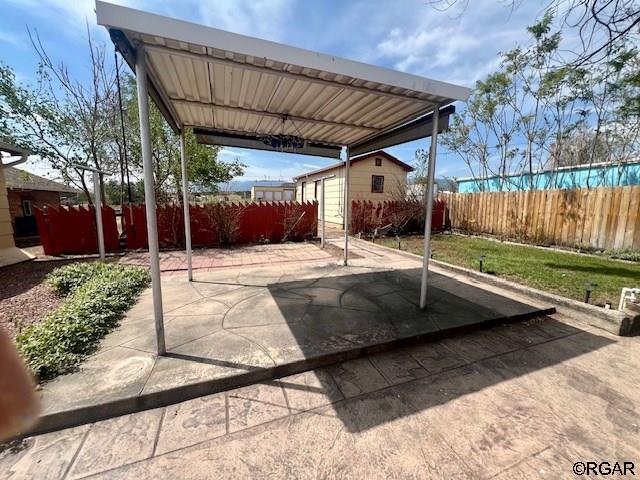 view of patio / terrace featuring an outbuilding and a carport