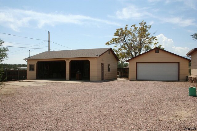 view of front of house featuring a garage and an outbuilding