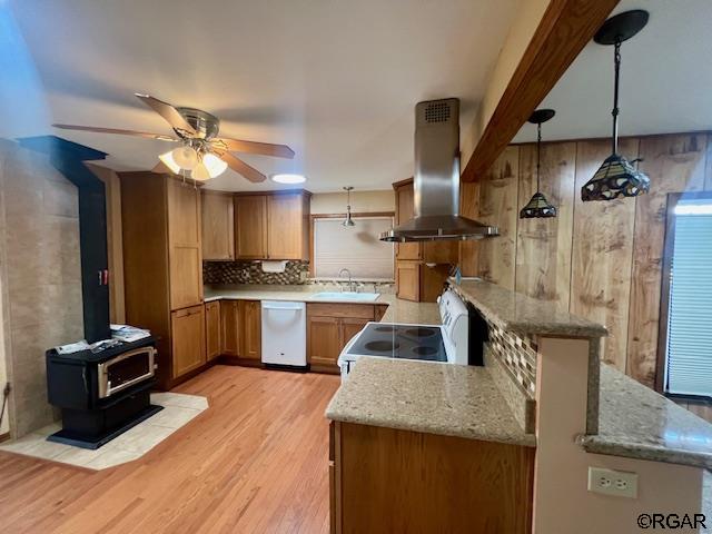 kitchen featuring island exhaust hood, sink, tasteful backsplash, hanging light fixtures, and white appliances