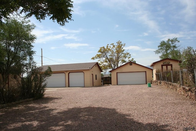 ranch-style home with a garage and an outbuilding