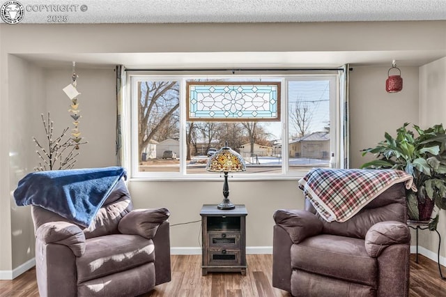 living area with hardwood / wood-style flooring and a textured ceiling