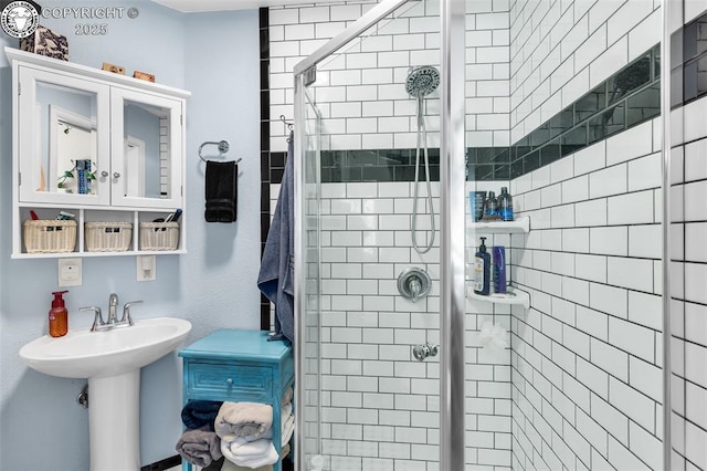 bathroom with sink and a shower with shower door