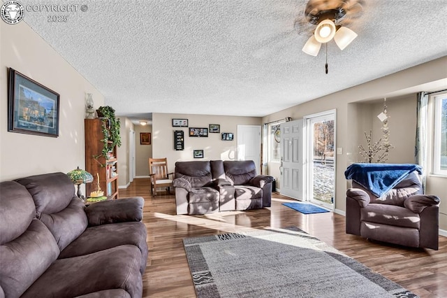 living room with ceiling fan, hardwood / wood-style flooring, and a textured ceiling