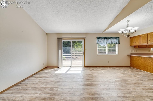 168 Willmoor Ct, Canon City, CO 81212 - unfurnished dining area featuring light wood finished floors, a chandelier, a textured ceiling, and vaulted ceiling
