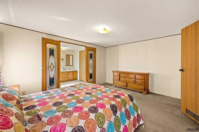 carpeted bedroom featuring ensuite bath and a textured ceiling