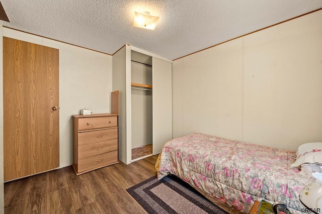 bedroom featuring dark wood-type flooring, a closet, and a textured ceiling