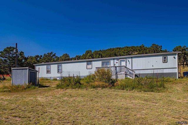 view of front of house featuring a storage unit and a front yard