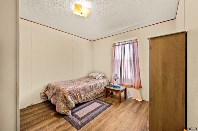 bedroom featuring hardwood / wood-style floors and a textured ceiling