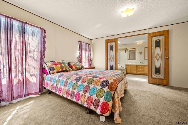 carpeted bedroom with a textured ceiling and ensuite bath