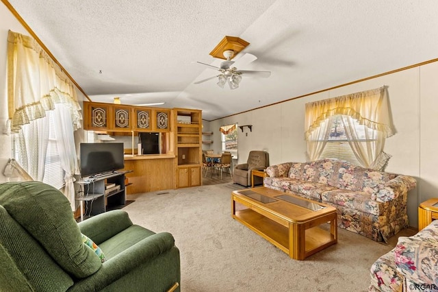 living room featuring lofted ceiling, ceiling fan, ornamental molding, a textured ceiling, and light colored carpet