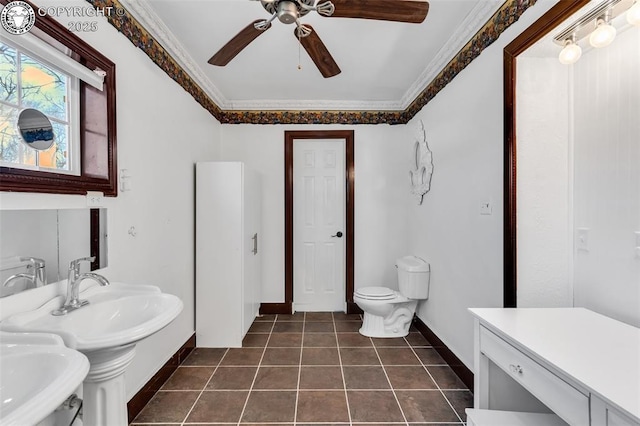 bathroom featuring tile patterned flooring, double sink, ceiling fan, toilet, and crown molding