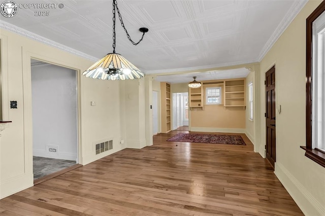 dining room with hardwood / wood-style floors, ornamental molding, and built in features