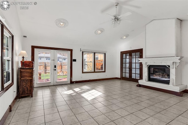 unfurnished living room with french doors, lofted ceiling, a fireplace, and light tile patterned flooring