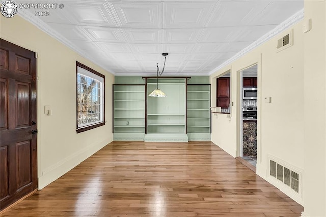 interior space with hardwood / wood-style floors and crown molding