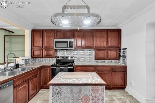 kitchen with stainless steel appliances, a center island, sink, and backsplash