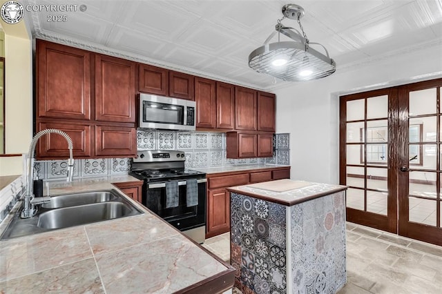 kitchen with french doors, sink, a center island, stainless steel appliances, and decorative backsplash