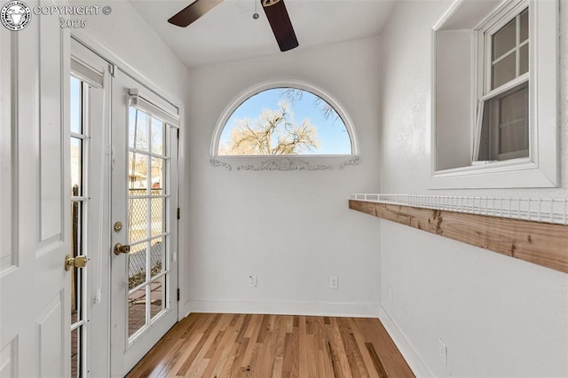 doorway with ceiling fan and light hardwood / wood-style flooring