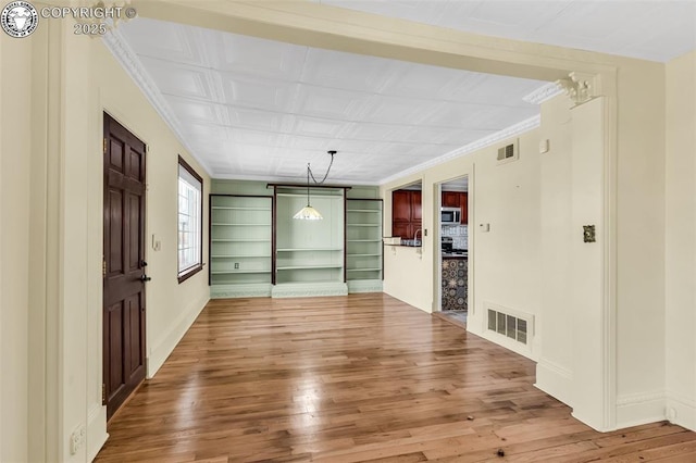 interior space with hardwood / wood-style flooring and ornamental molding