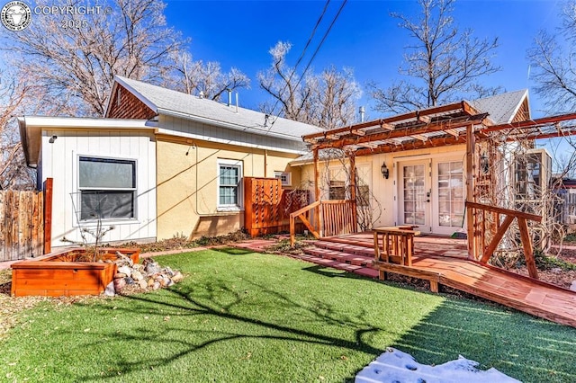 back of property with a yard and french doors