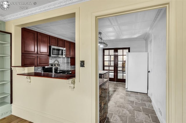 kitchen with decorative backsplash, ornamental molding, stainless steel appliances, and french doors