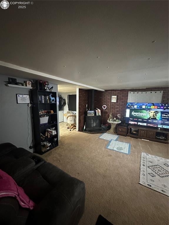 living room with brick wall, carpet, and a wood stove