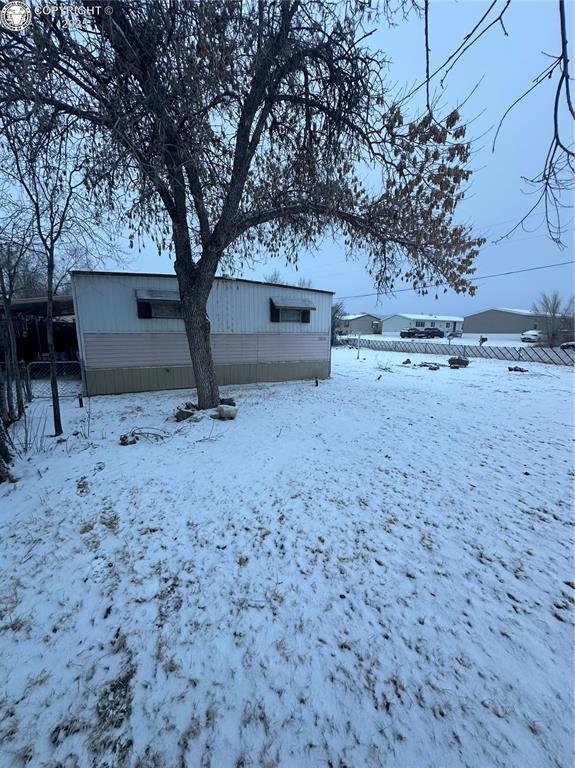 view of snow covered back of property