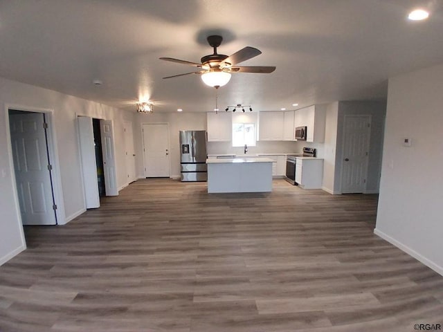 kitchen with hardwood / wood-style floors, white cabinetry, a center island, ceiling fan, and stainless steel appliances