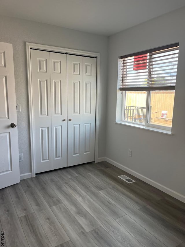 unfurnished bedroom featuring light hardwood / wood-style floors and a closet