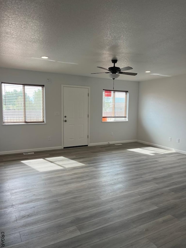 empty room with hardwood / wood-style flooring, ceiling fan, and a textured ceiling