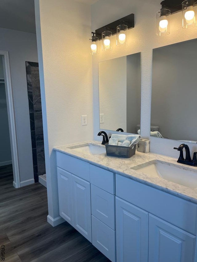 bathroom featuring hardwood / wood-style flooring, vanity, and walk in shower