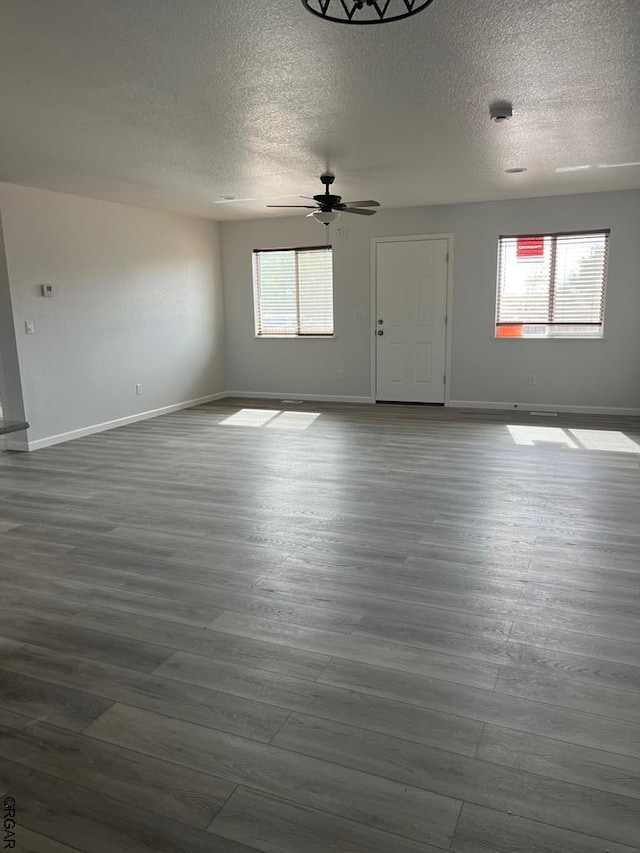 empty room featuring hardwood / wood-style flooring, ceiling fan, and a textured ceiling