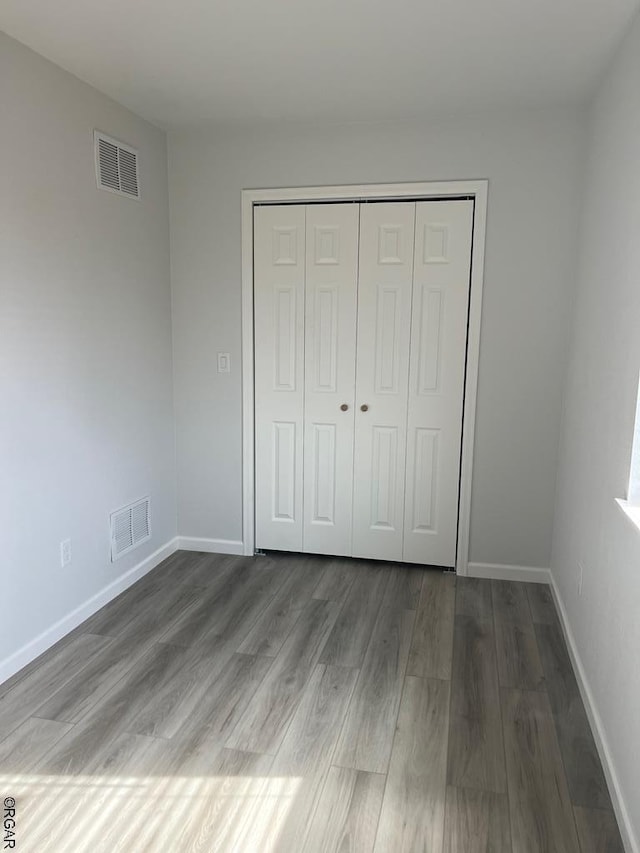 unfurnished bedroom featuring hardwood / wood-style floors and a closet