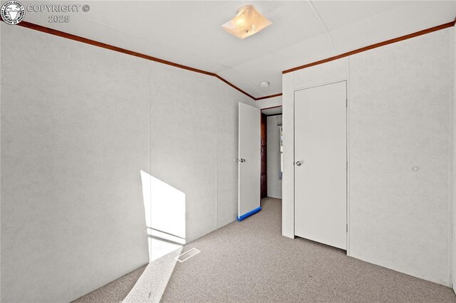 unfurnished room with lofted ceiling and light carpet