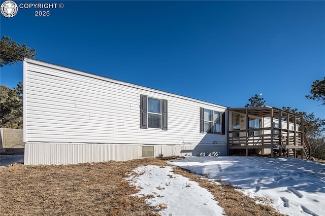 snow covered property with a deck