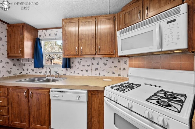 kitchen with white appliances, sink, and a textured ceiling