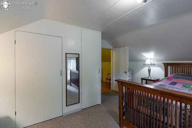 bedroom with vaulted ceiling and carpet flooring