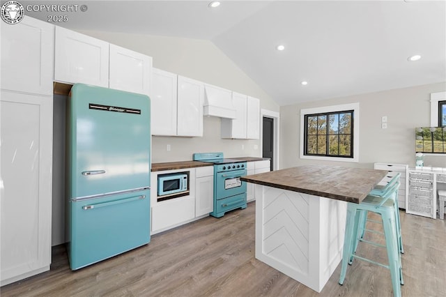 kitchen featuring white cabinets, light wood-style floors, stove, fridge, and wooden counters