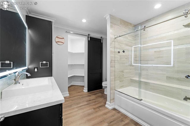 full bath with toilet, ornamental molding, enclosed tub / shower combo, vanity, and wood finished floors