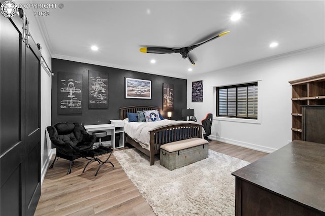 bedroom featuring ornamental molding, a barn door, light wood-style flooring, and recessed lighting