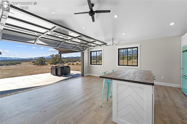 kitchen with white cabinets, wooden counters, light wood-style flooring, and a kitchen breakfast bar