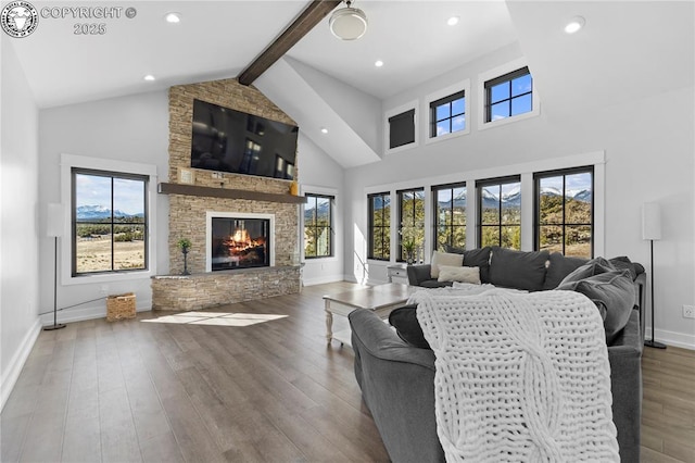 living area with high vaulted ceiling, a fireplace, wood finished floors, and beam ceiling