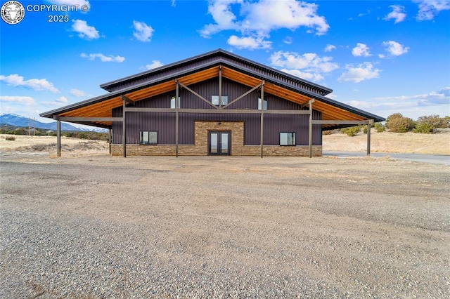 view of front of house featuring stone siding, french doors, and a mountain view