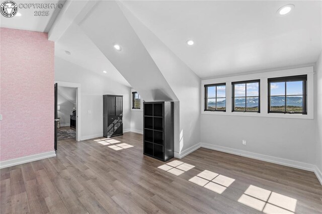 interior space featuring recessed lighting, baseboards, lofted ceiling with beams, and light wood finished floors