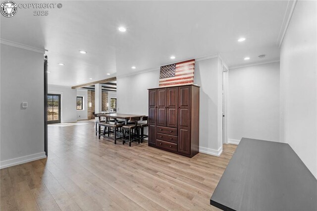 kitchen featuring light wood-type flooring, open floor plan, crown molding, and recessed lighting