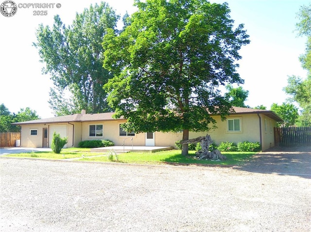 1207 Eugene Dr, Canon City, CO 81212 - ranch-style home featuring an attached garage, driveway, and stucco siding