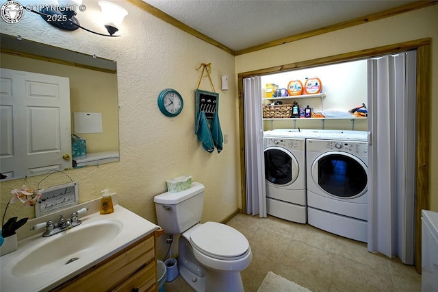 bathroom featuring crown molding, vanity, toilet, washing machine and dryer, and a textured ceiling