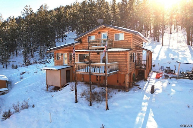 snow covered house featuring a deck