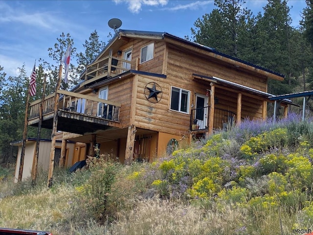 rear view of house featuring a wooden deck