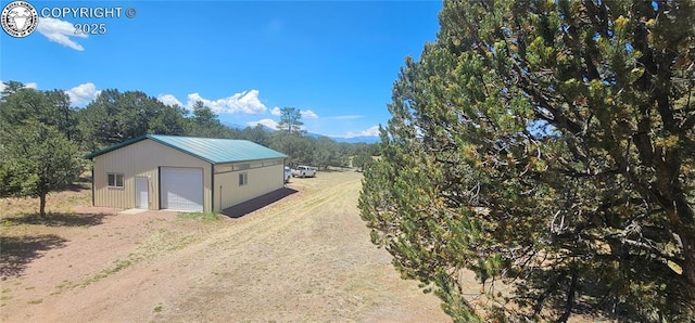 104 Sleepy Hollow Trl, Cotopaxi, CO 81223 - view of side of property with an outbuilding, a garage, driveway, and a metal roof